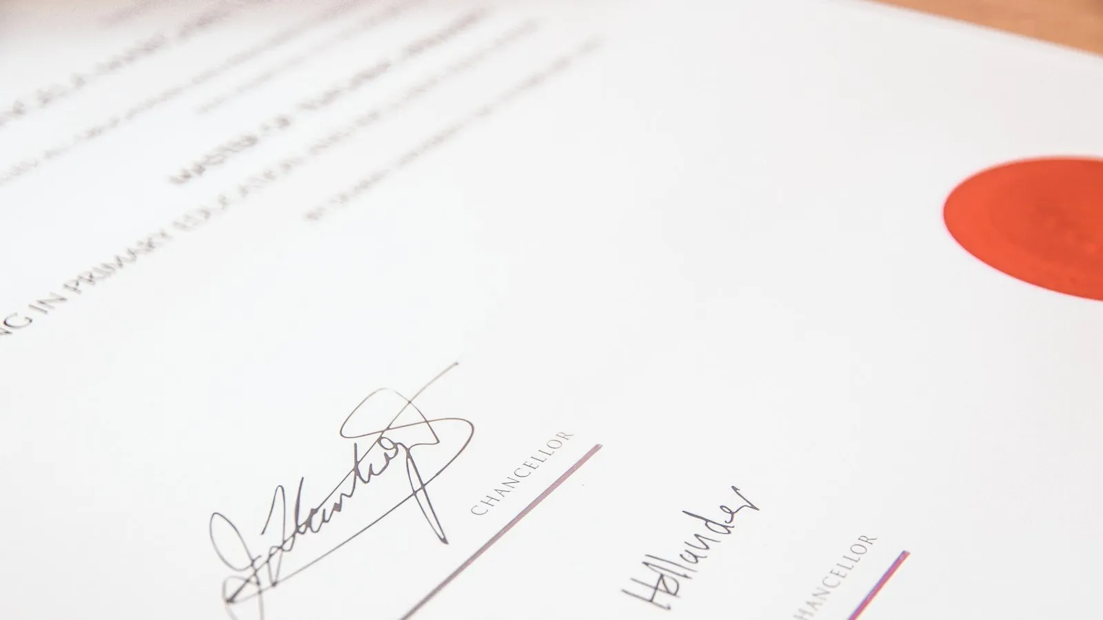 Close-up of a printed certificate with signatures and a red seal.